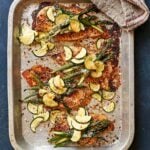 Peri peri chicken cheddar bake in a roasting tray with asparagus and courgette, golden spiced crust, overhead shot